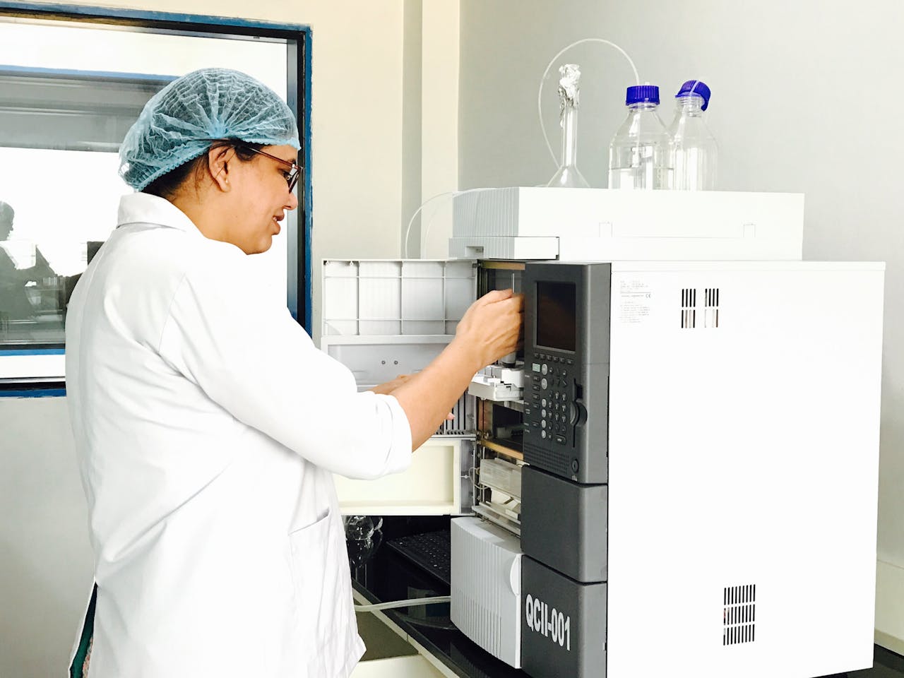 Female scientist using advanced analytical chemistry equipment in a laboratory.